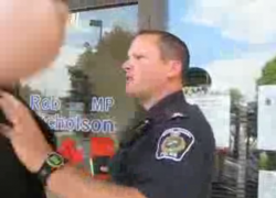 The police officer slaps Hunter's phone out of his hand and then puts his hands on the activist's chest before grabbing his lapels and shoving violently.